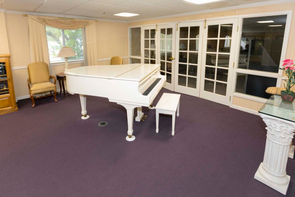 A bright common area with a white piano