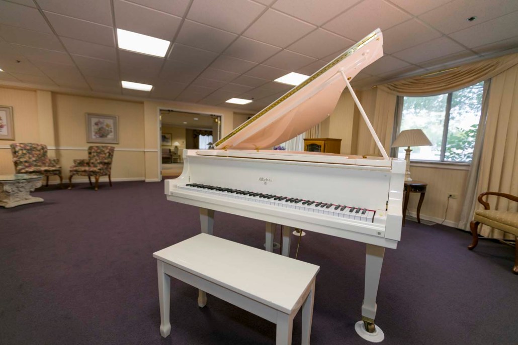 A white piano in a cozy lounge area