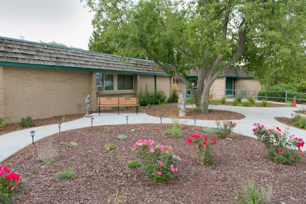 Garden area with flowers and benches near the facility