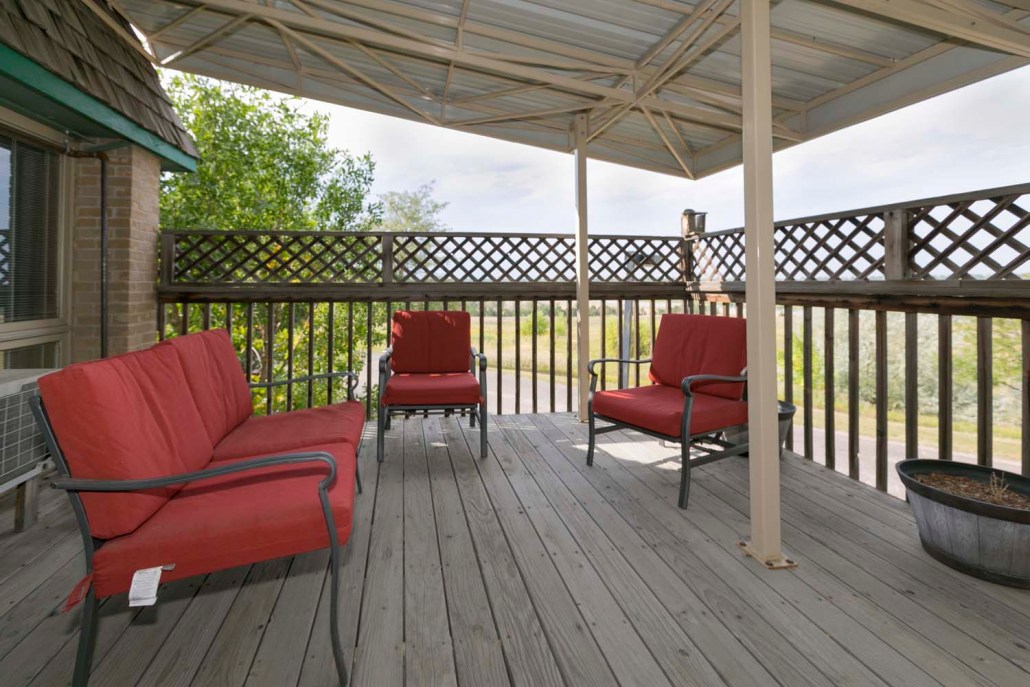 Outdoor seating area with red chairs on a wooden deck