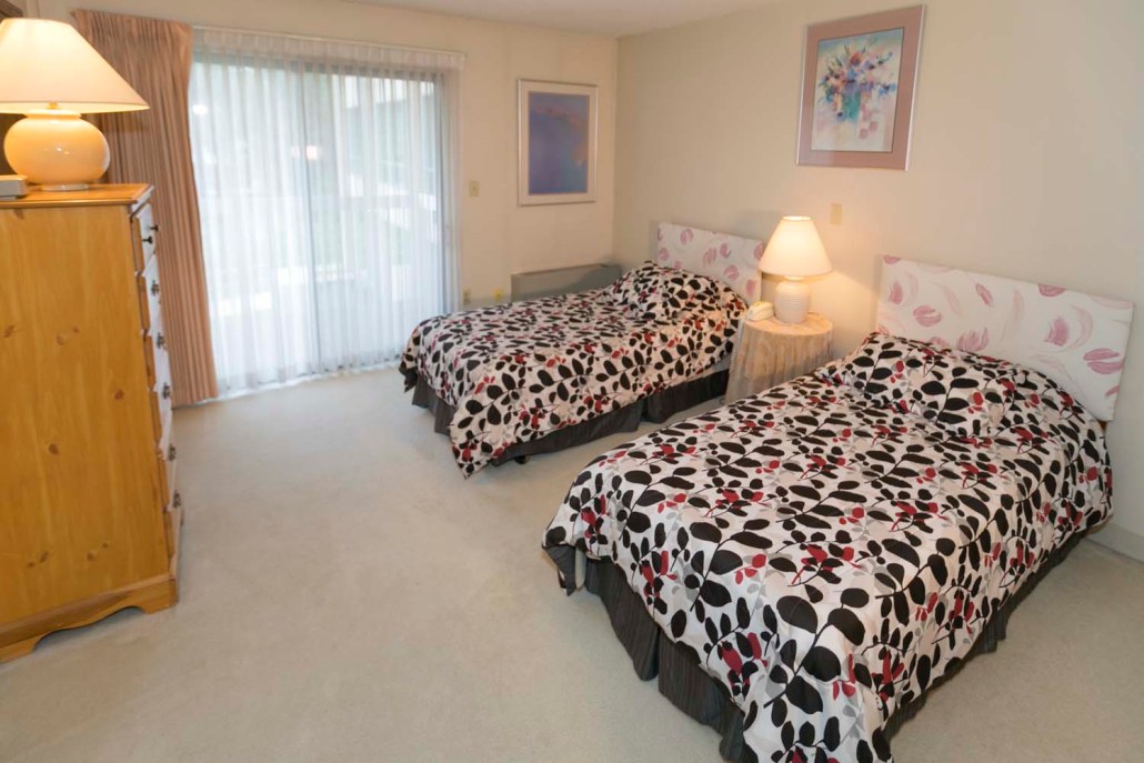 A cozy shared room with two beds and soft lighting
