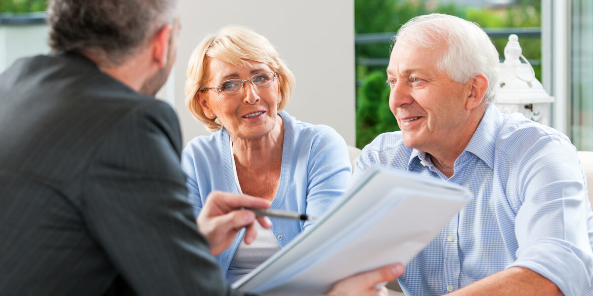 Seniors engaging in conversation with a staff member