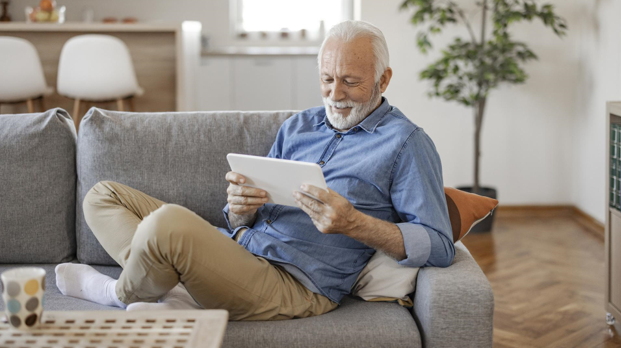 Senior man enjoying a tablet in a cozy living room