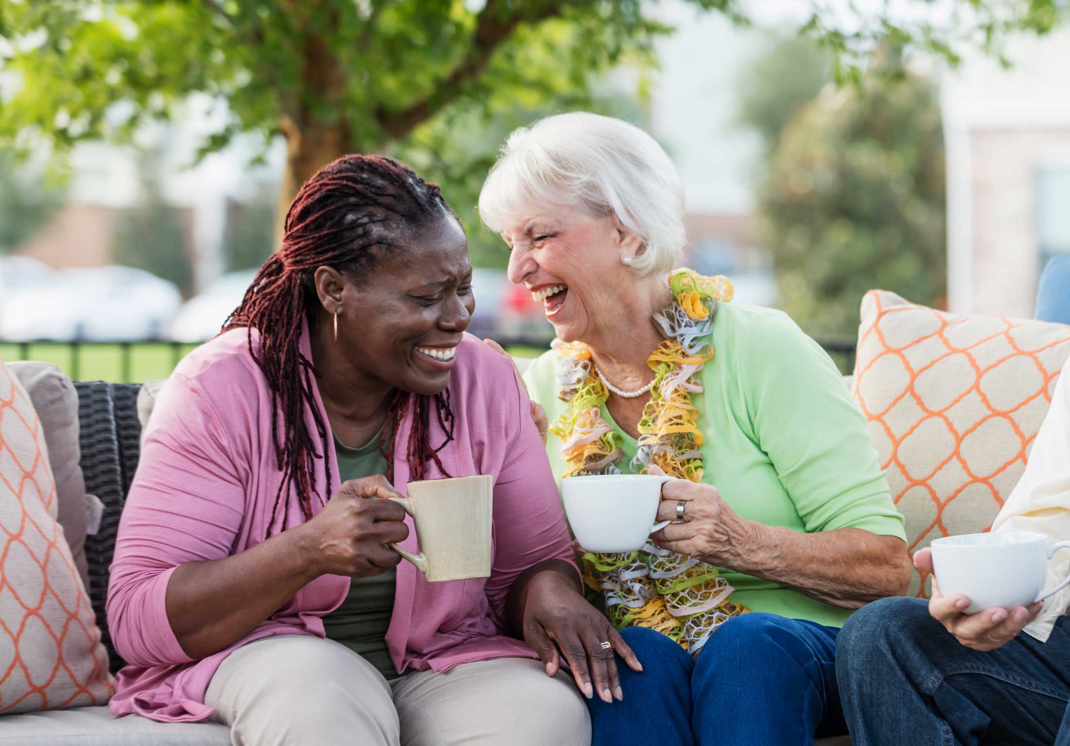 Two residents enjoying coffee together outdoors