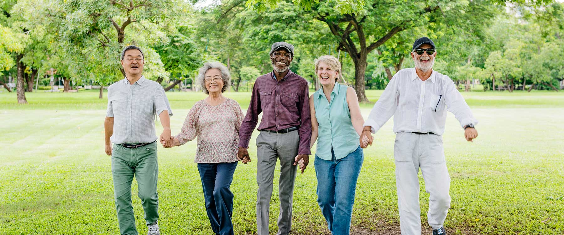 Seniors walking together in a green park