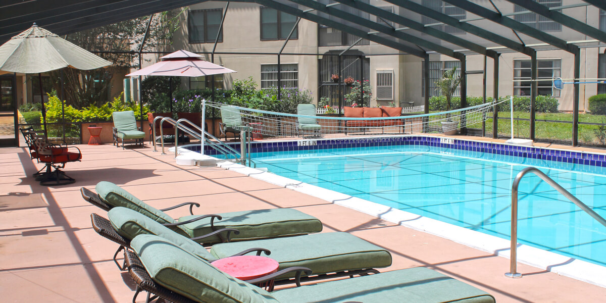Swimming pool area with lounge chairs and umbrellas