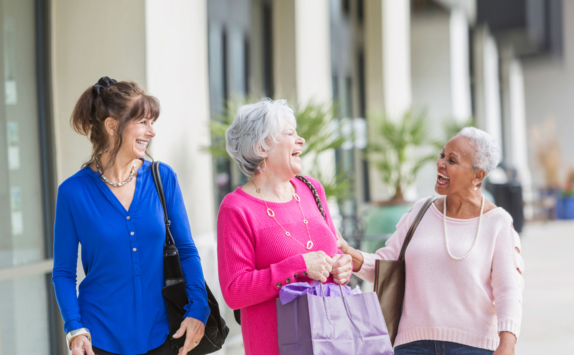 Three women smiling and enjoying time together outside