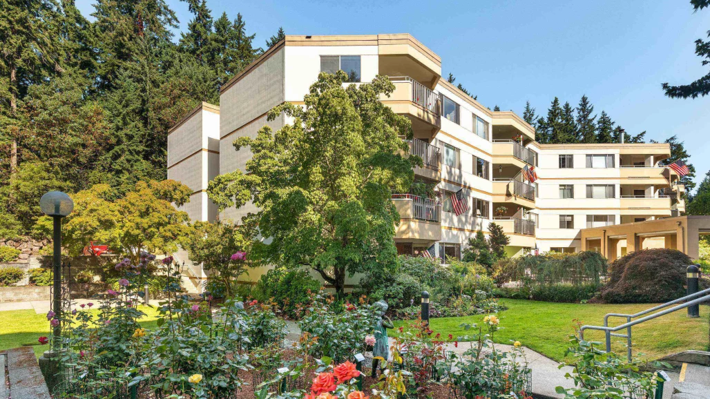 Exterior view of a senior living facility with gardens