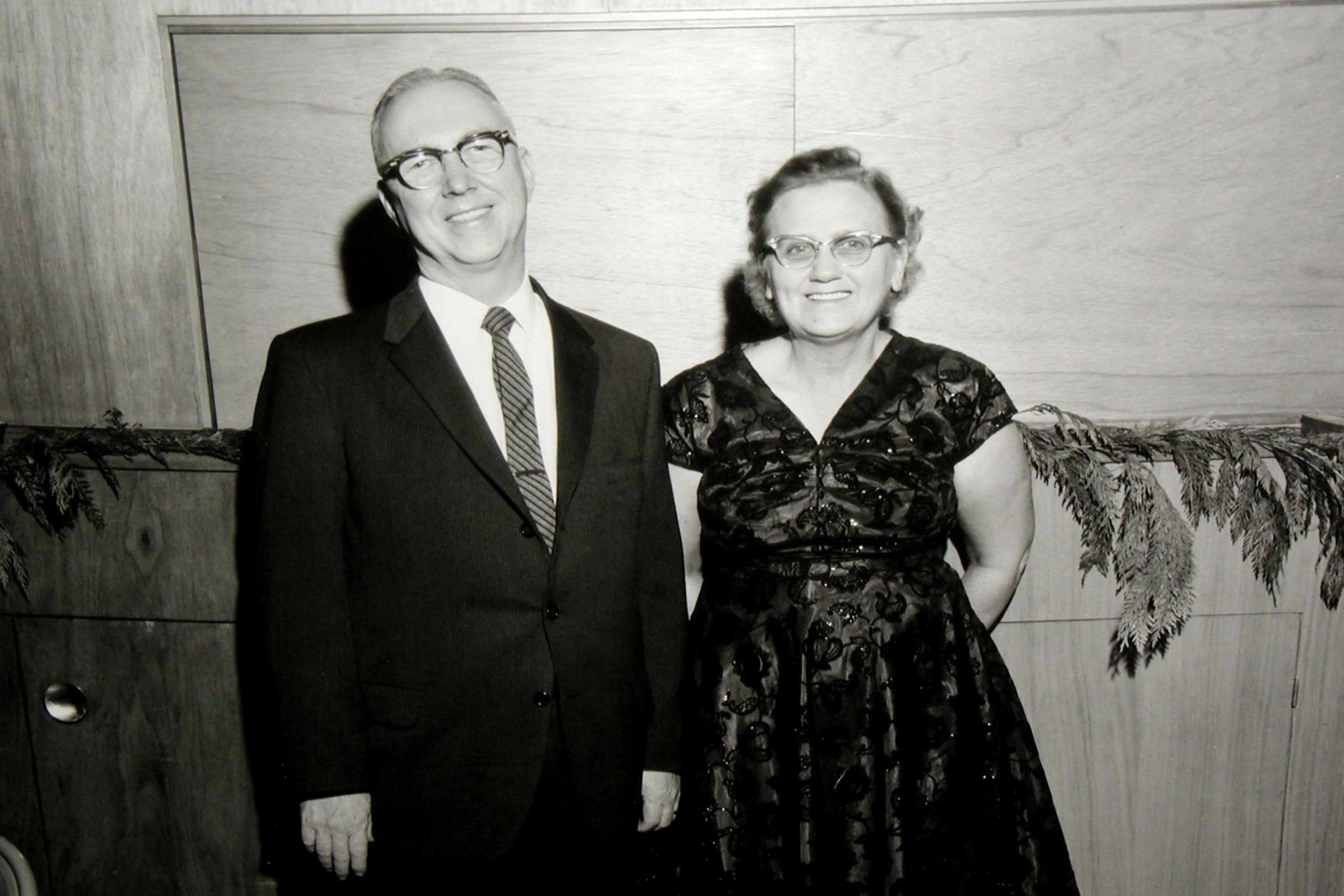 A couple posing together in formal attire.