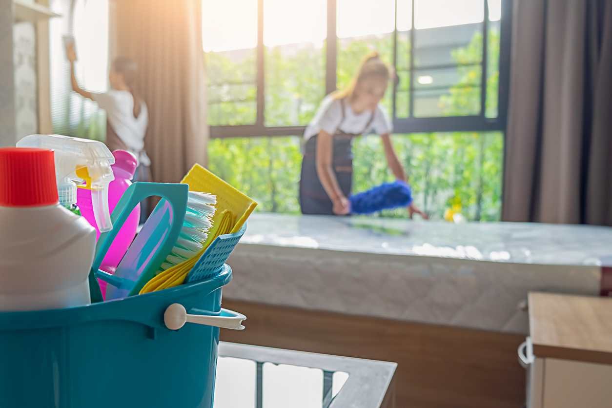 Staff cleaning a resident room in a well-lit interior