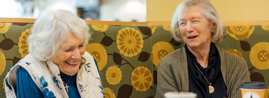 Two residents laughing in a cozy common area