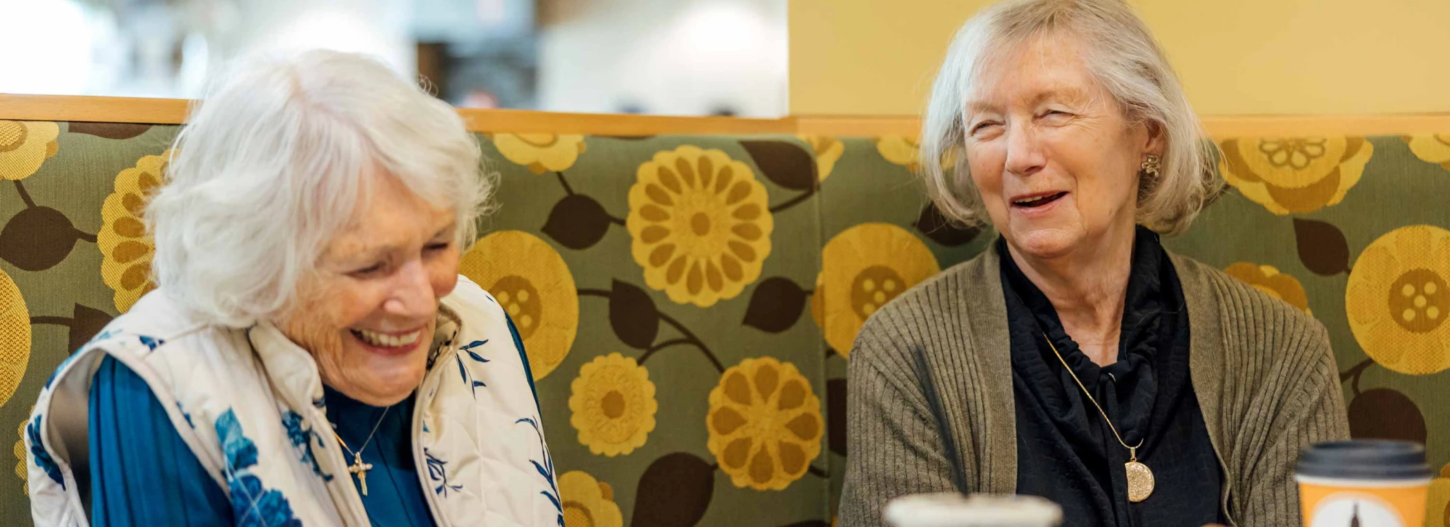 Two residents laughing in a cozy common area