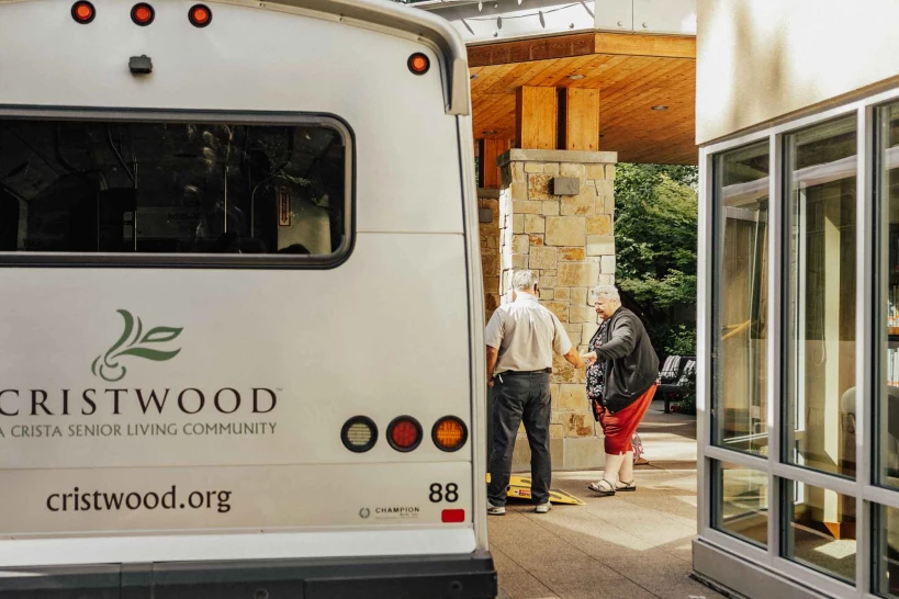 Residents interacting with staff near facility transport