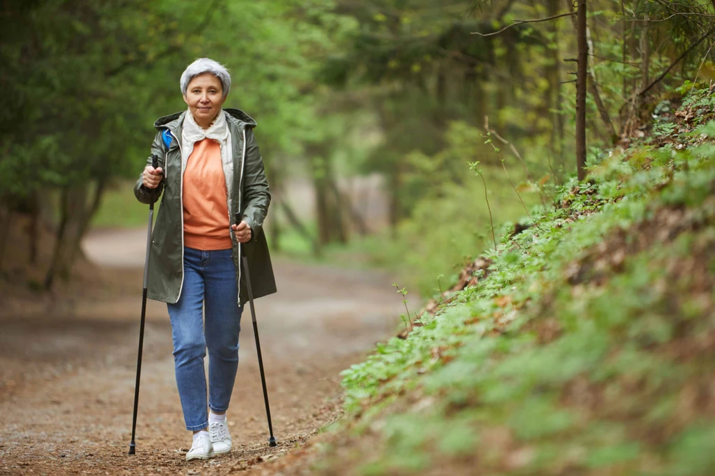 Senior woman hiking on a forest path