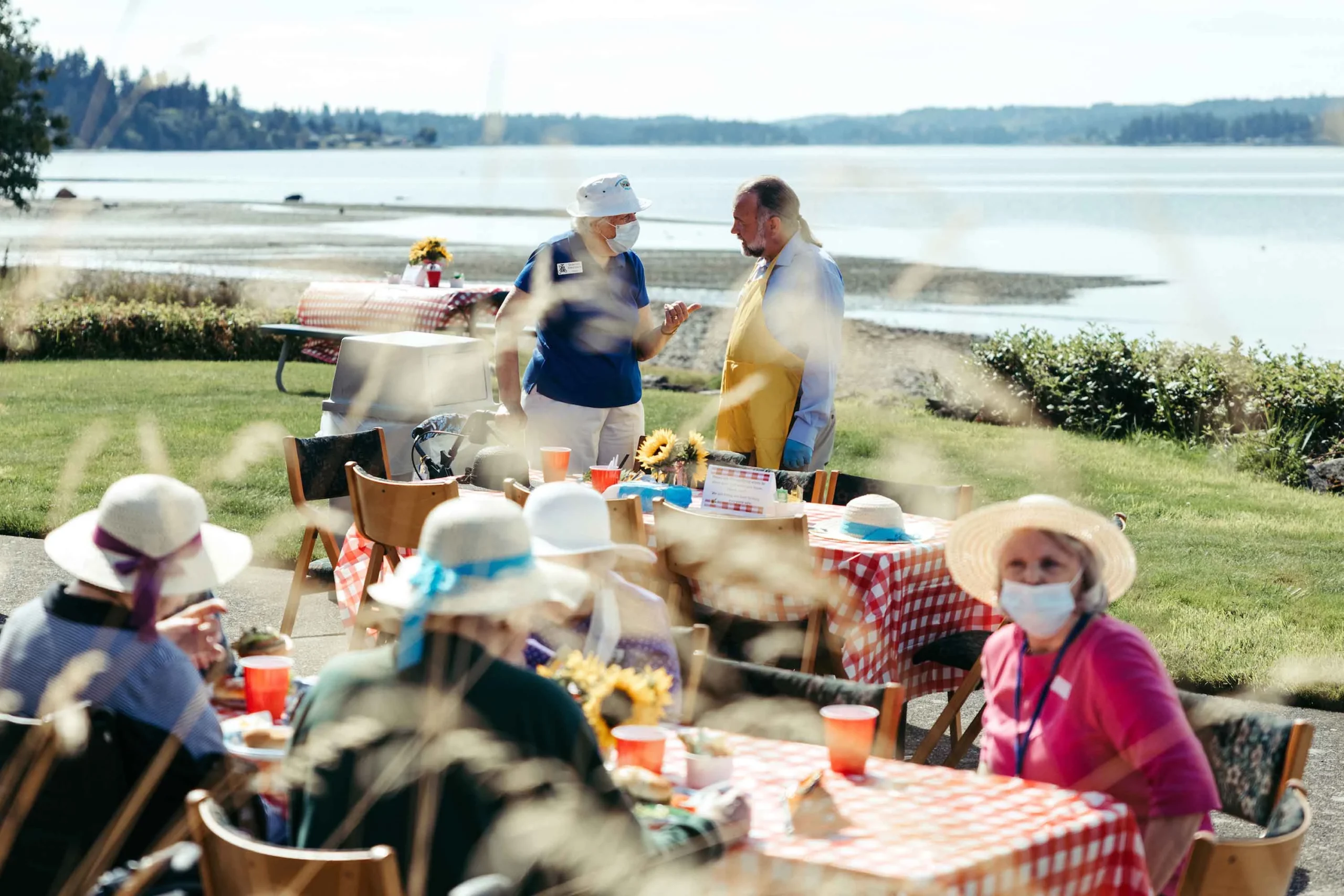 Residents and staff enjoying an outdoor gathering by the water