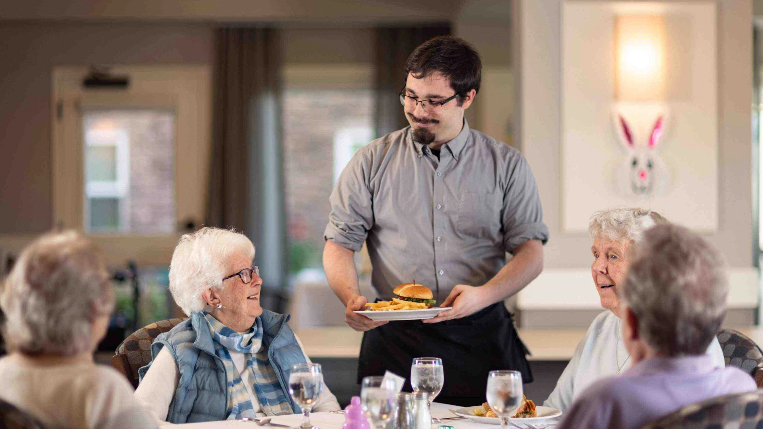 Staff serving food to residents in a dining room