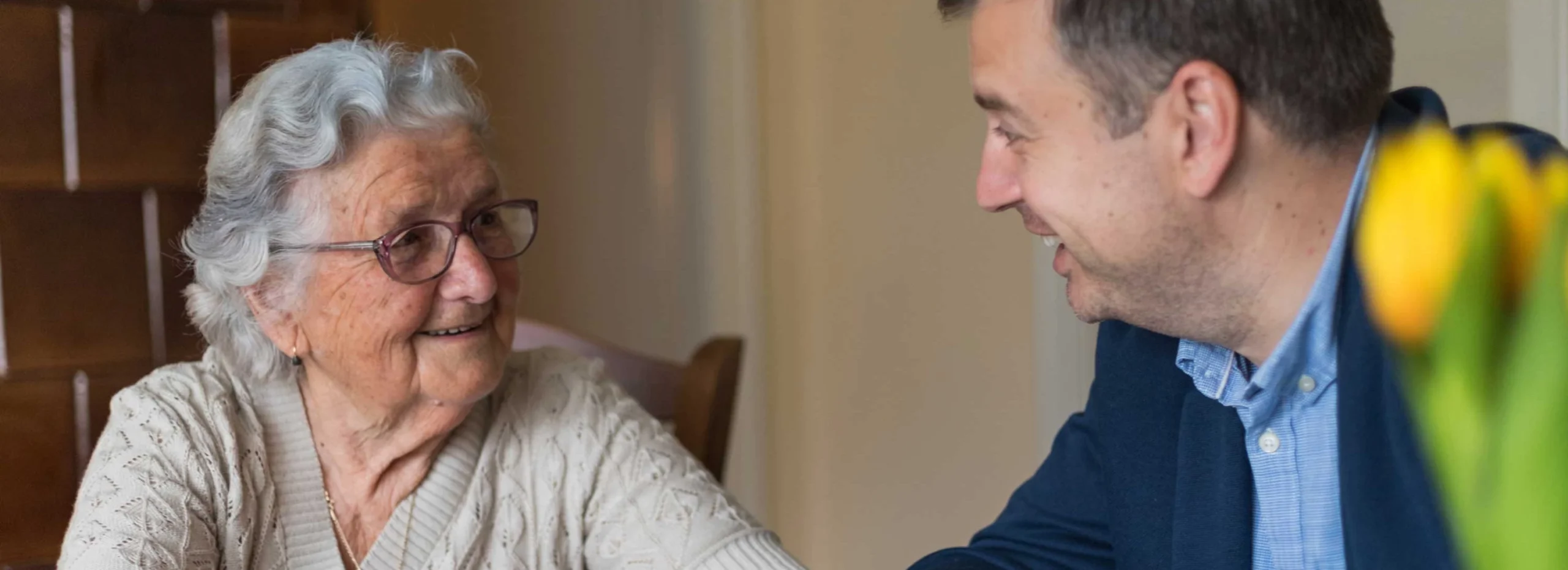 A senior woman smiling while talking with a staff member