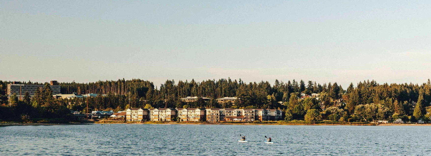 View of Cristwood facility by the water with people kayaking