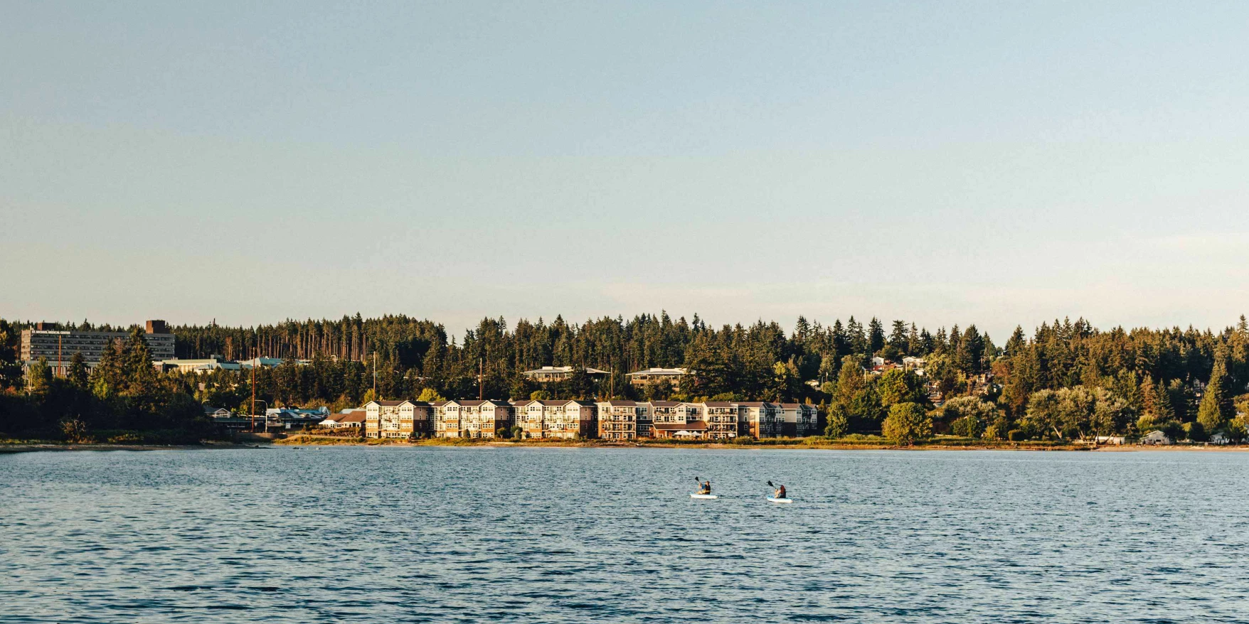Assisted living facility by the water surrounded by trees