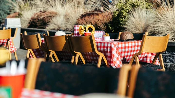 Outdoor dining area with checkered tablecloths and flowers