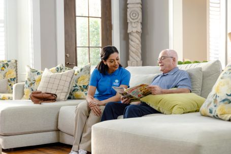 Caregiver engaging with a senior resident in a cozy setting.