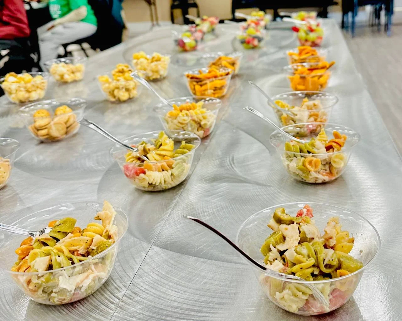 Colorful salads served in plastic bowls on a table.
