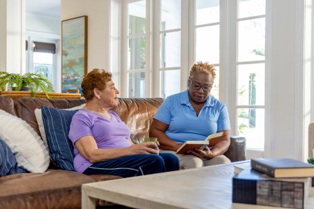Two women engaged in conversation at a cozy common area.