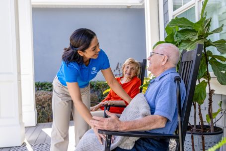 Caregiver interacting with a senior outdoors.