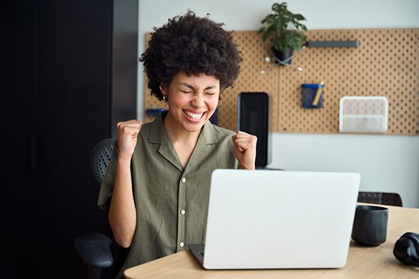 Smiling person celebrating at a desk