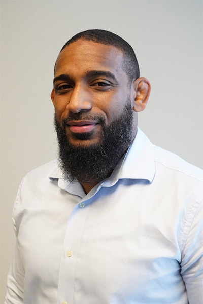 Portrait of a man with a beard in a light shirt.