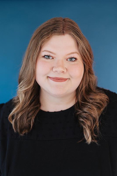Smiling staff member with a blue background