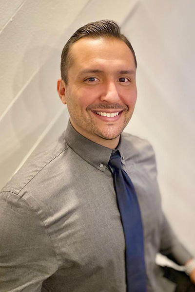 Staff member smiling in a casual setting.