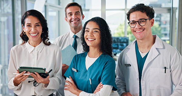 Four cheerful staff members in a facility setting.