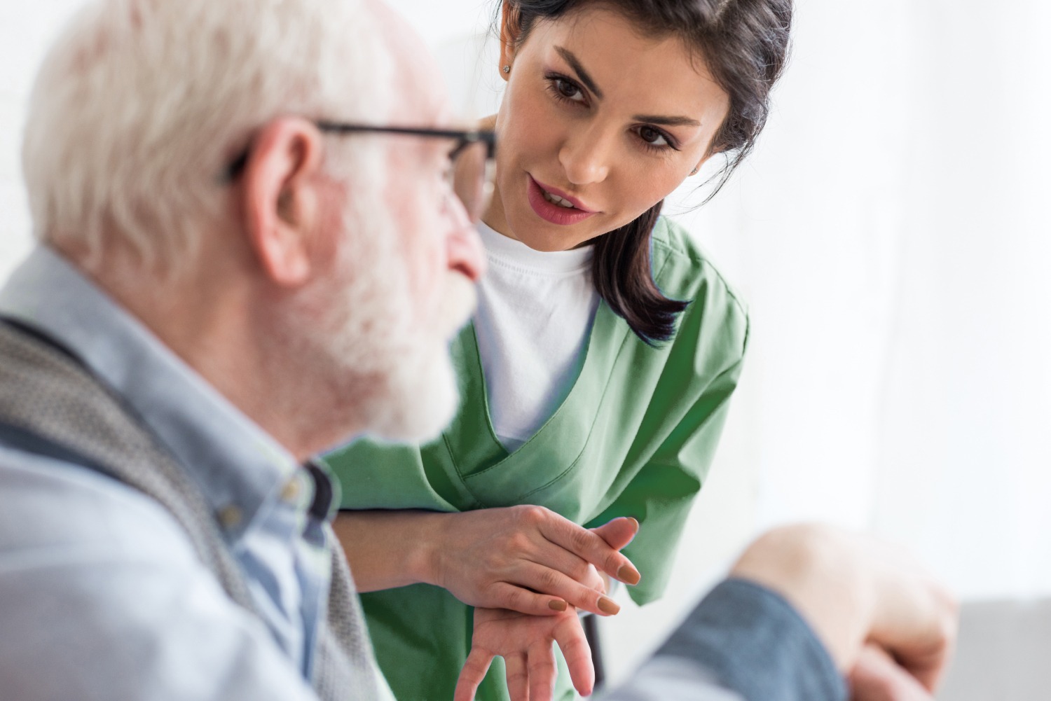 Nurse assisting an elderly man with conversation.