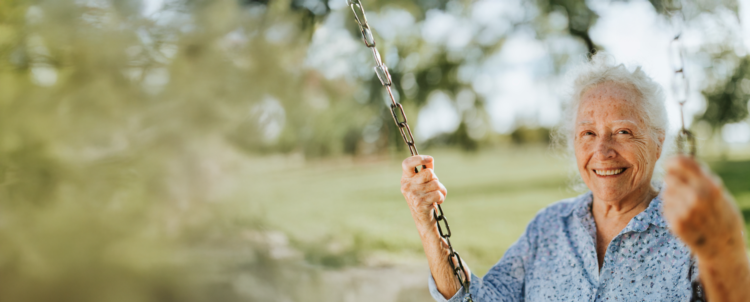 Happy senior woman enjoying a swing outdoors.