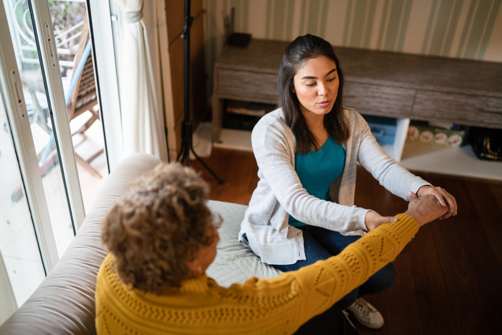 Caregiver assisting a senior resident in a cozy setting.