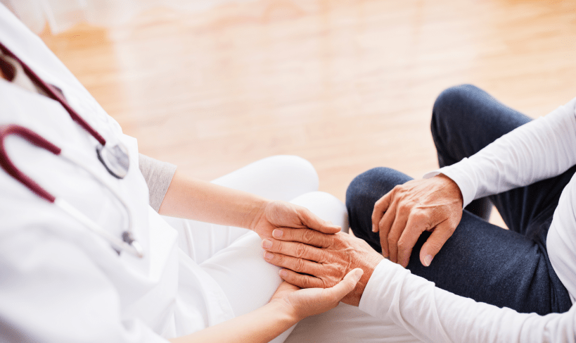 Healthcare professional holding hands of a senior
