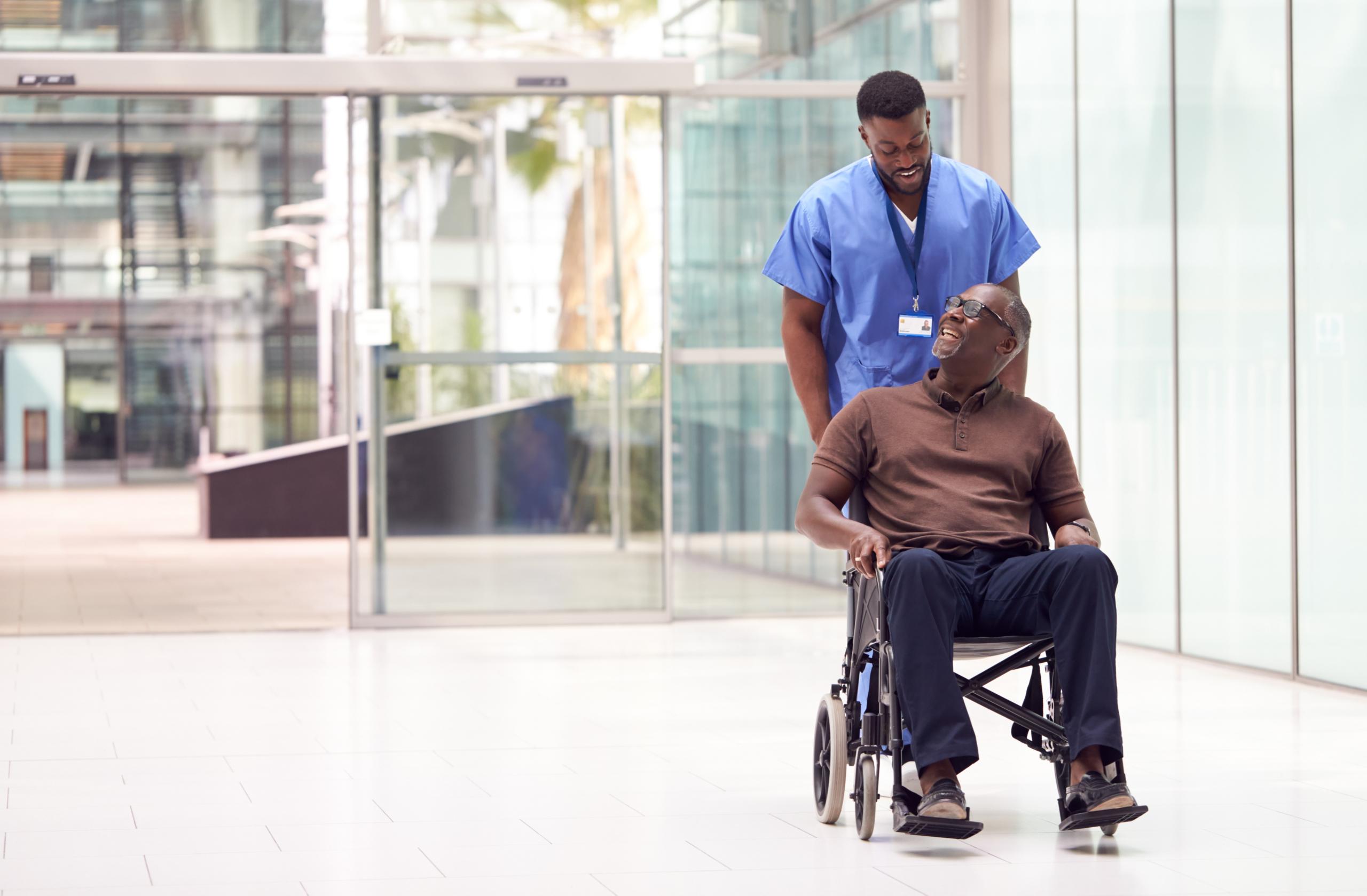 Staff assisting resident in a wheelchair indoors