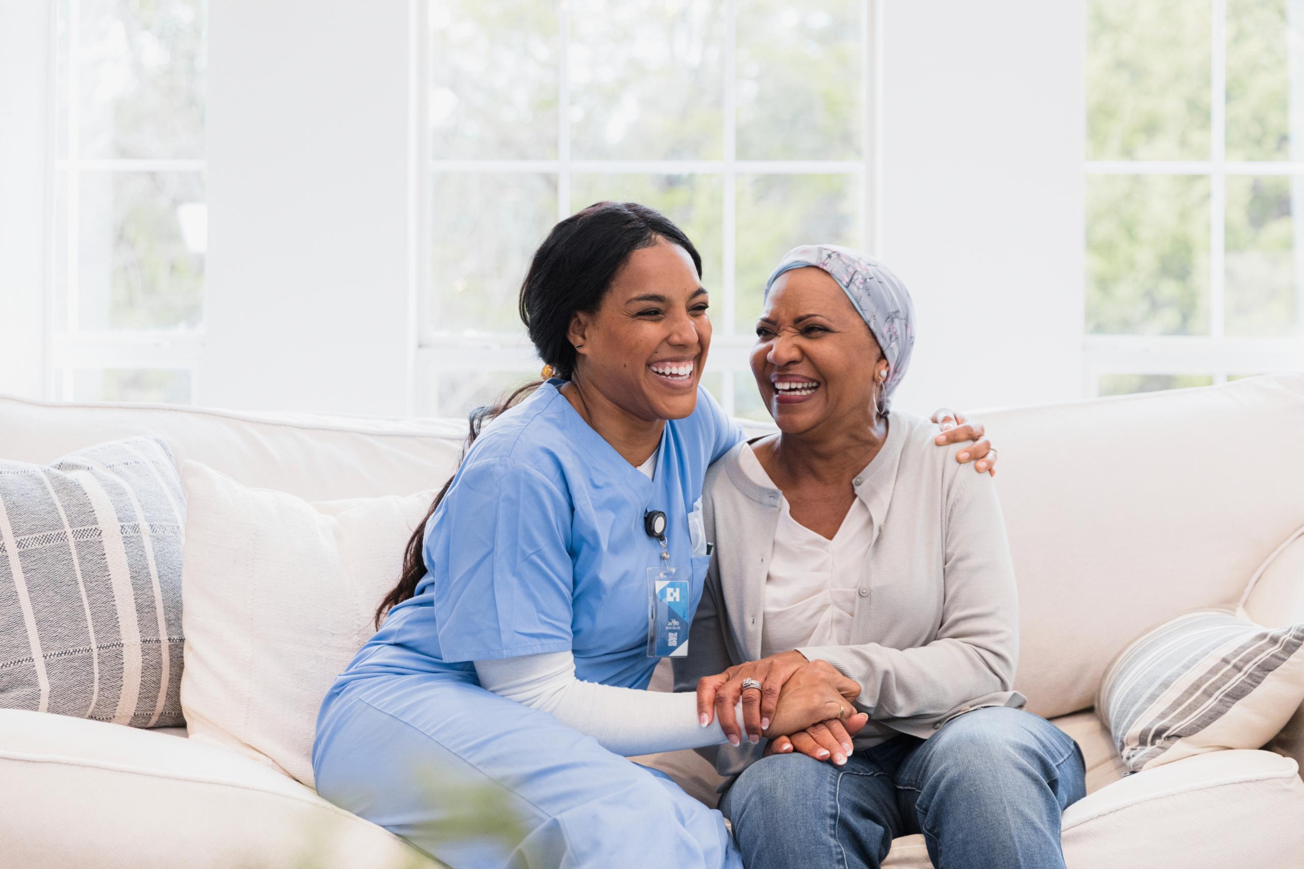 Caregiver and resident sharing a joyful moment indoors.