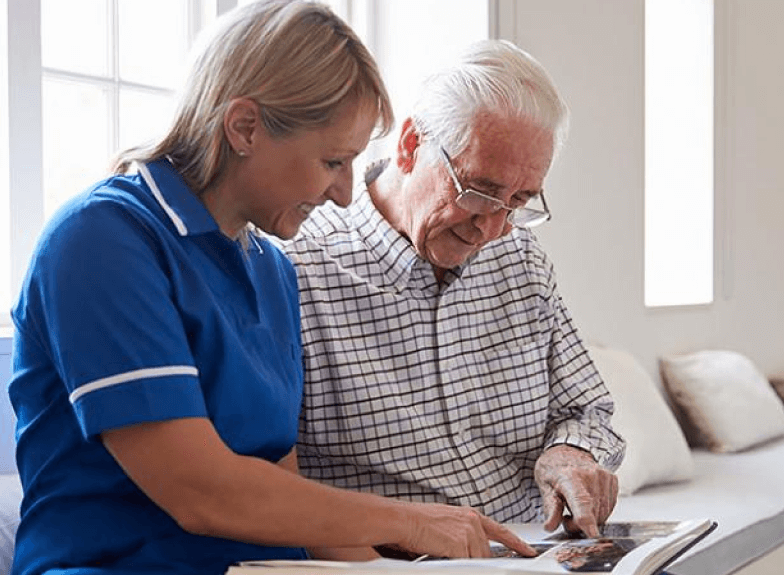 Caregiver reading with elderly resident