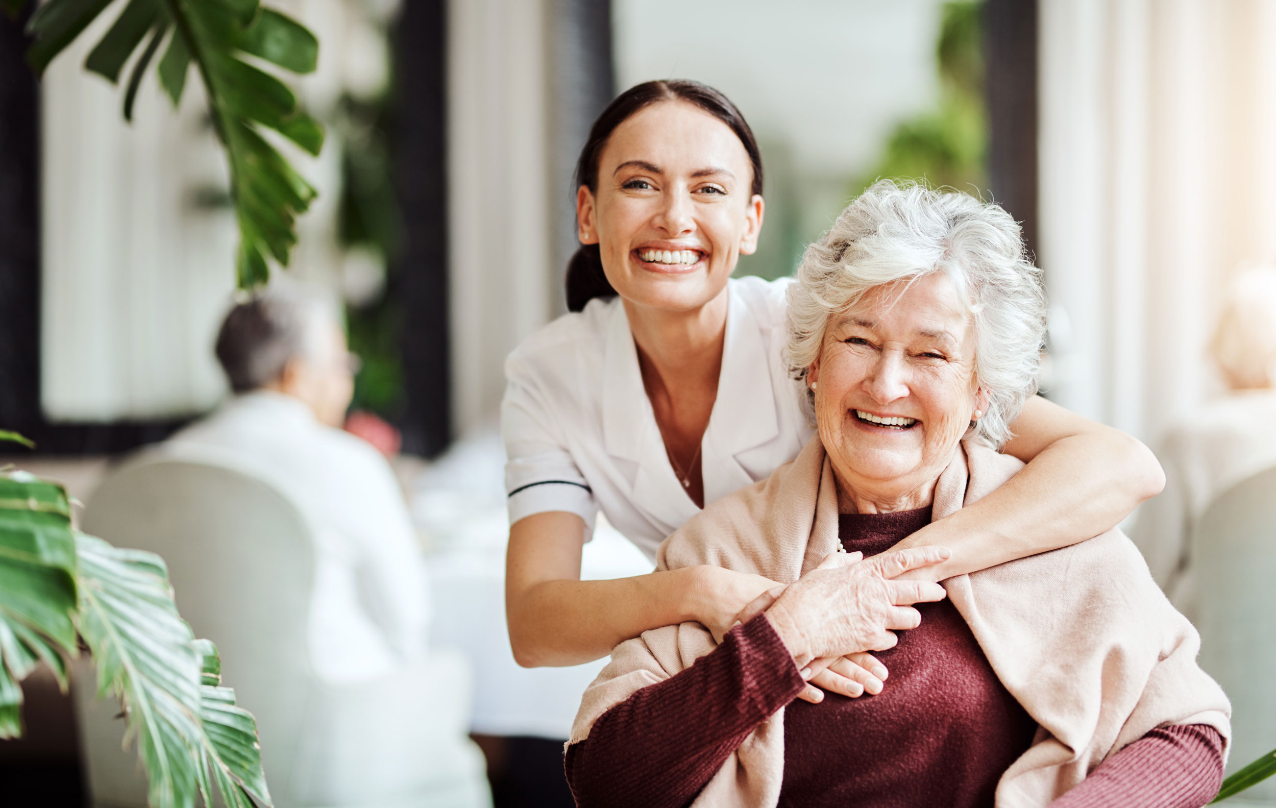 A caregiver and a resident smiling together.