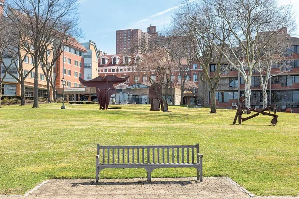 Outdoor sculpture area with a bench and green lawn