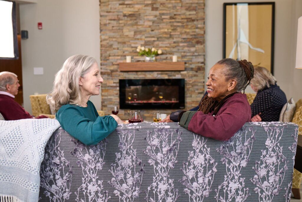 Two women chatting in a cozy common area