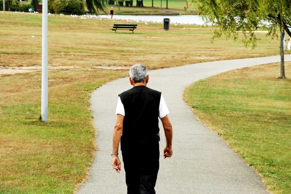 Senior walking along a path in a park
