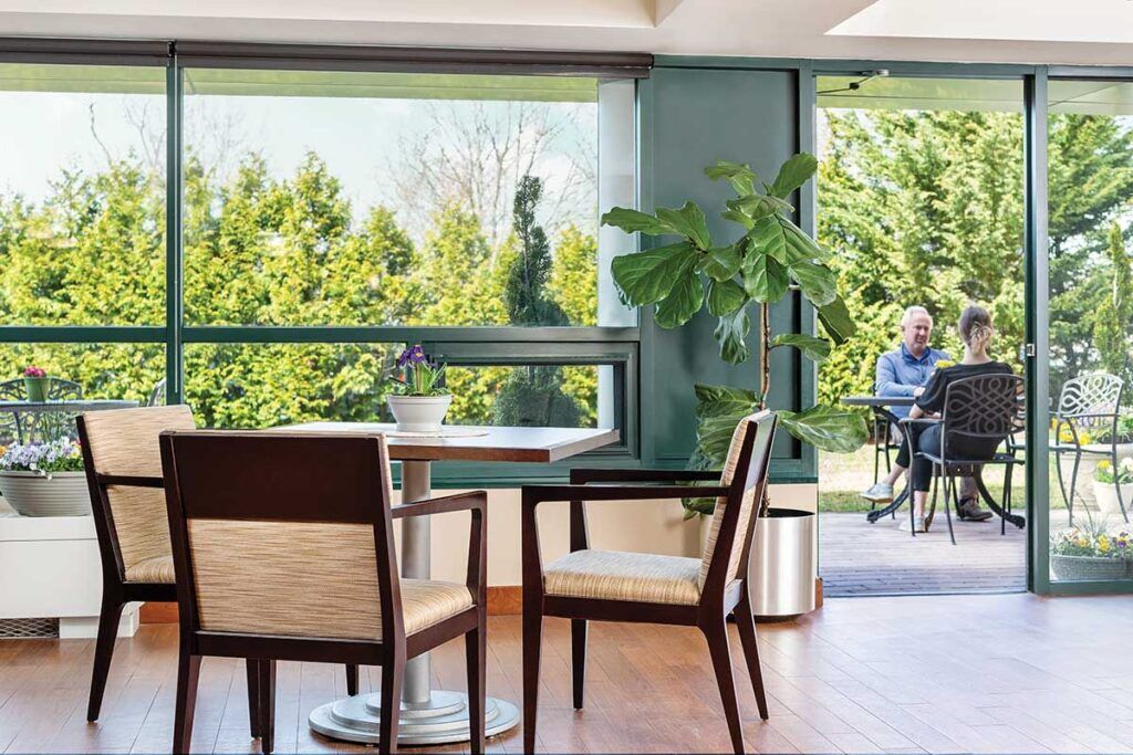 Common area with chairs, plants, and outdoor seating view.