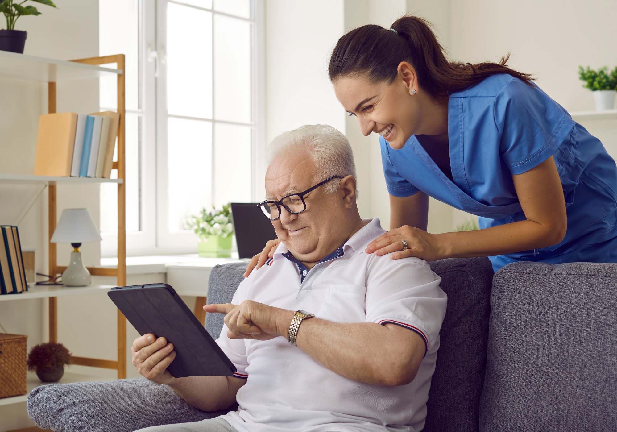Caregiver and resident enjoying time with a tablet.