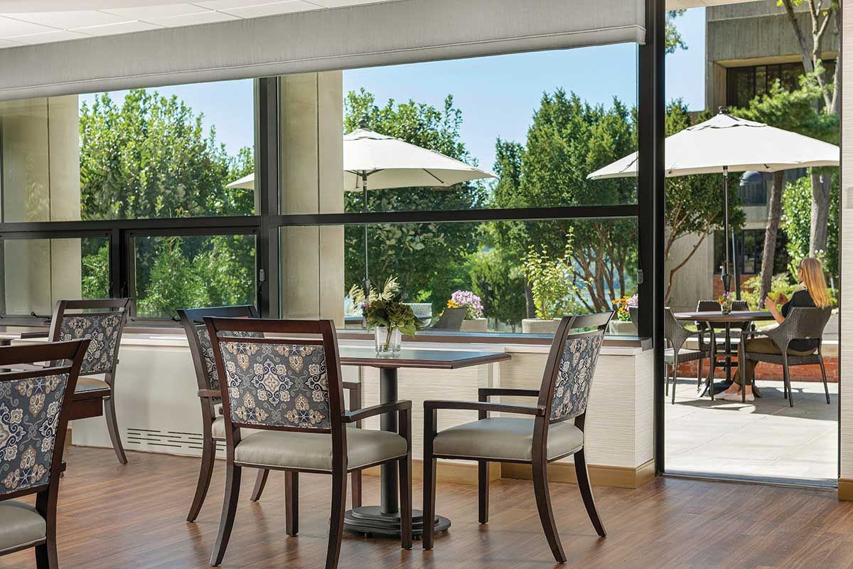 Bright common area with dining tables and outdoor view.
