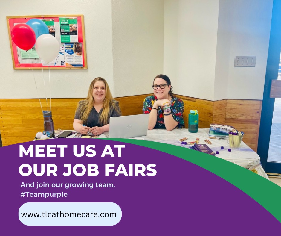 Staff members at a recruitment table with balloons.