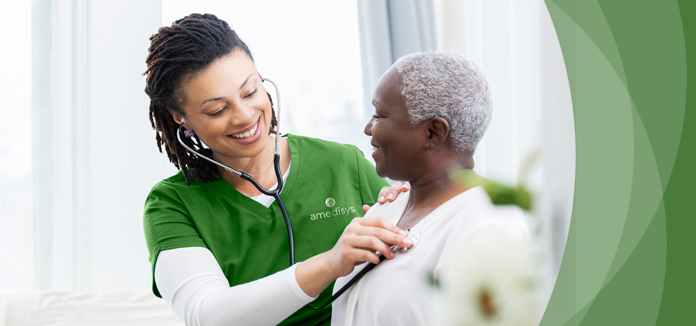 Nurse checking a resident's heartbeat in a cozy interior
