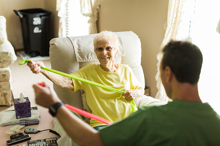 Senior resident exercising with resistance bands.